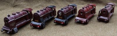 several toy trains are lined up in a row on the floor