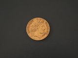 a close up of a gold coin on a black surface