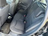 the back seats of a car with a bottle of beer in it