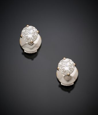 une paire de boucles d'oreilles en diamant sur une surface noire