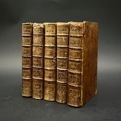 trois vieux livres empilés les uns sur les autres sur une surface noire
