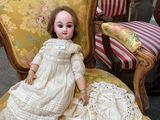 a doll that is sitting on a chair in a room