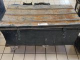une grande boîte métallique posée sur un sol carrelé