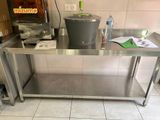 une table en acier inoxydable sur laquelle est posé un seau