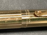 a close up of a gold colored pen with a black cap