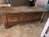 a wooden table with a wooden top in the middle of a room