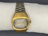 une montre-bracelet posée sur une serviette blanche, sur une surface noire