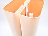 two orange bins with pens and pencils in them