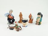 five figurines of people sitting on a white surface