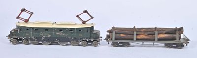 deux petits trains jouets transportant des bûches, posés sur une surface blanche