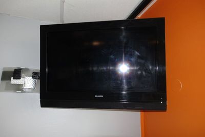 un téléviseur à écran plat fixé au mur d'une pièce