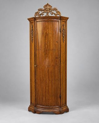 une armoire d'angle ancienne en bois, avec un plateau sculpté