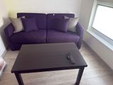 a purple couch and a black coffee table in a living room