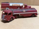 un petit camion rouge et un autre petit camion rouge posés sur une table