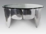 une table basse ovale en verre, avec un piètement en métal et un plateau en verre transparent