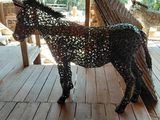 a horse made out of wire on a wooden floor