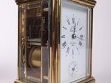 a small gold clock with roman numerals on it