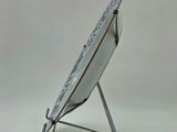 a white plate on a stand with a blue and white design