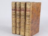 three old books sitting on top of each other on a white surface