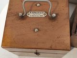 a small wooden box with a metal handle on a table