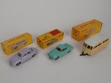 four toy cars are sitting next to each other on a white surface