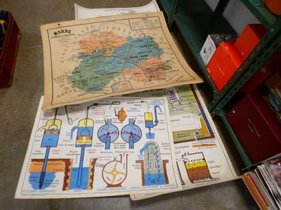 a pile of maps on the floor next to a book shelf