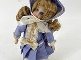 figurine en porcelaine représentant une petite fille vêtue d'une robe bleue et d'un bonnet