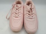 une paire de baskets roses posées sur une surface blanche