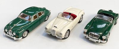 trois petites voitures vertes et blanches sont alignées sur une surface blanche