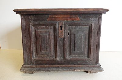 un petit meuble en bois surmonté d'une porte