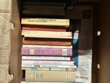 a cardboard box filled with lots of books on top of a table
