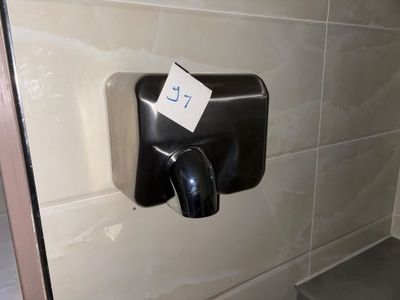 un distributeur de savon noir fixé au mur dans une salle de bains