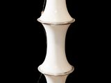 un grand vase blanc posé sur un fond noir