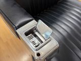 the back of a black leather office chair with a metal arm rest