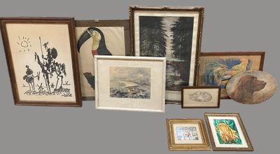 many framed and unframed art pieces on the table