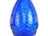 un vase en verre bleu orné d'un motif de feuilles
