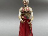 une figurine représentant un homme coiffé d'un turban et tenant une canne