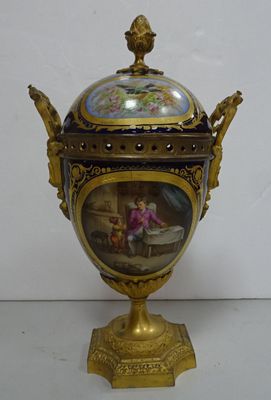 a golden vase with a painting on it on a table
