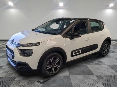 une citrole blanche garee sur un plancher en damier dans un garage