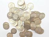 un tas de pièces de monnaie posées sur une surface blanche, sur fond blanc