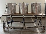 trois grands pots posés sur une table dans un garage