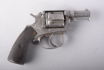 un pistolet posé sur une surface blanche