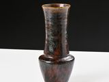 a brown vase sitting on a white table