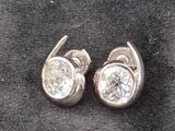 une paire de boucles d'oreilles en diamant posées sur un tissu noir