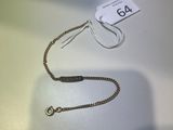 un collier en argent avec un fermoir en or posé sur une table