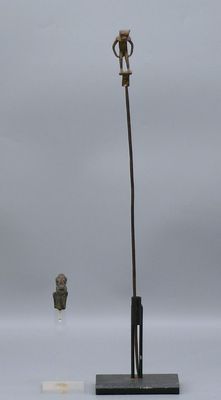 statue d'un homme coiffé d'un chapeau, fixée sur un poteau, à côté d'une statue d'un homme coiffé d'un chapeau, fixée sur un poteau