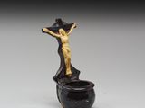 une image représentant une statue d'une personne sur une croix posée sur un pot