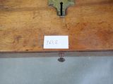 une étiquette apposée sur une boîte en bois sur laquelle figure une clé
