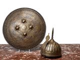 a large metal plate and a small metal bell on a table