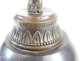 a silver vase with a cat on top of it